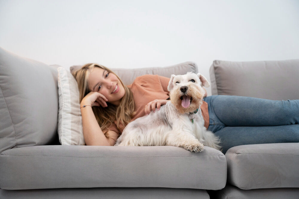 Girl lies on couch with her dog in a comfortable environment